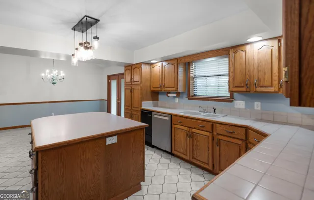 a kitchen with cabinets a sink dishwasher and a refrigerator