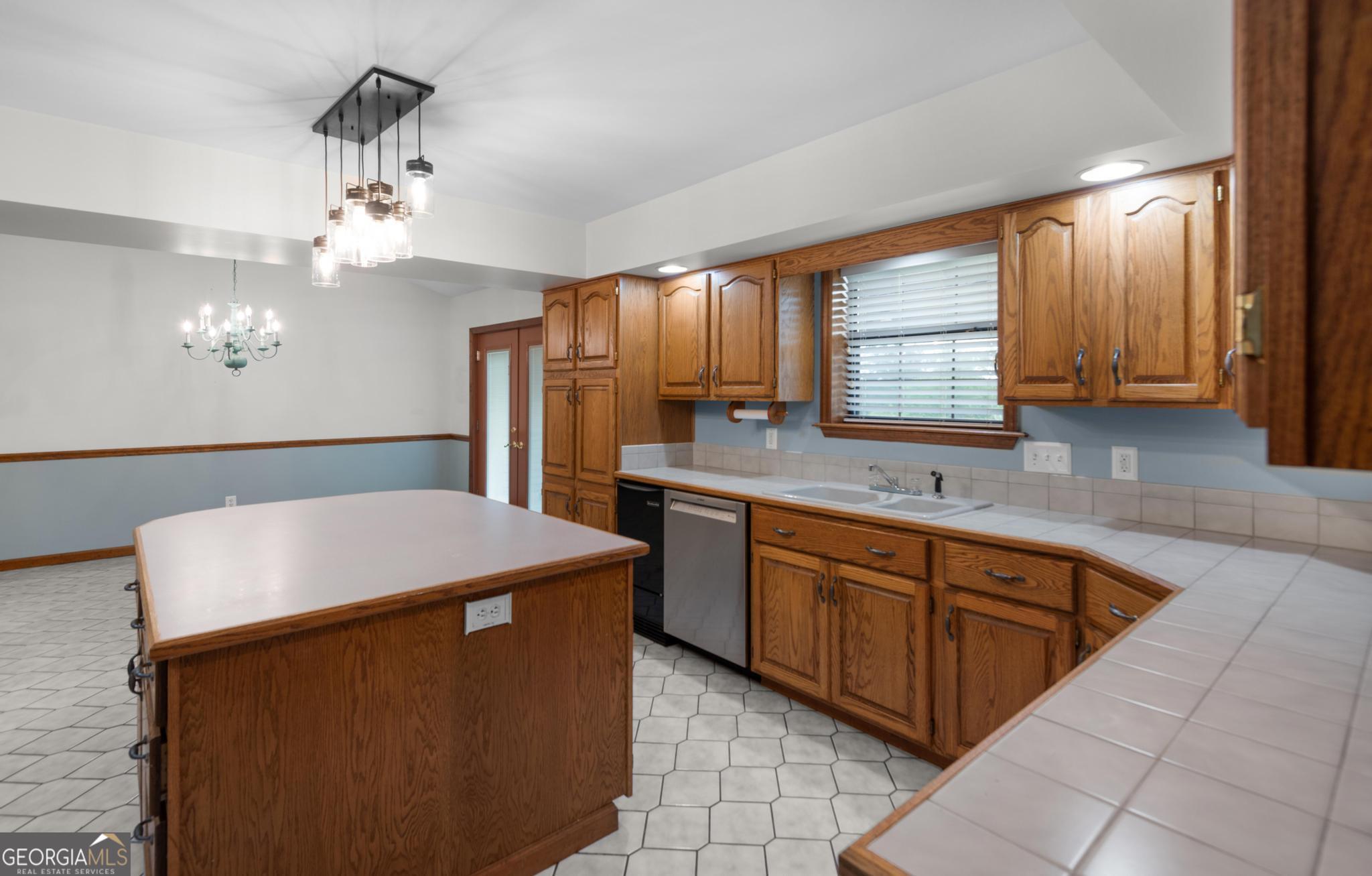 4909 Perry Road Claxton, GA 30417 - Photo 15 of 53 a kitchen with cabinets a sink dishwasher and a refrigerator