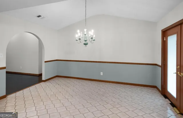 a view of a livingroom with a chandelier furniture and windows