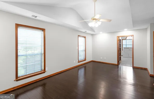 an empty room with a window and ceiling fan