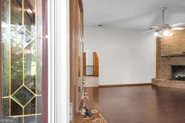 a view of a livingroom with wooden floor and a fireplace