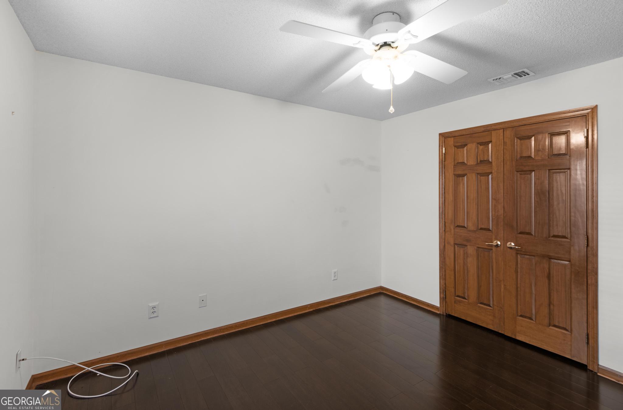 4909 Perry Road Claxton, GA 30417 - Photo 41 of 53 an empty room with a chandelier fan and windows