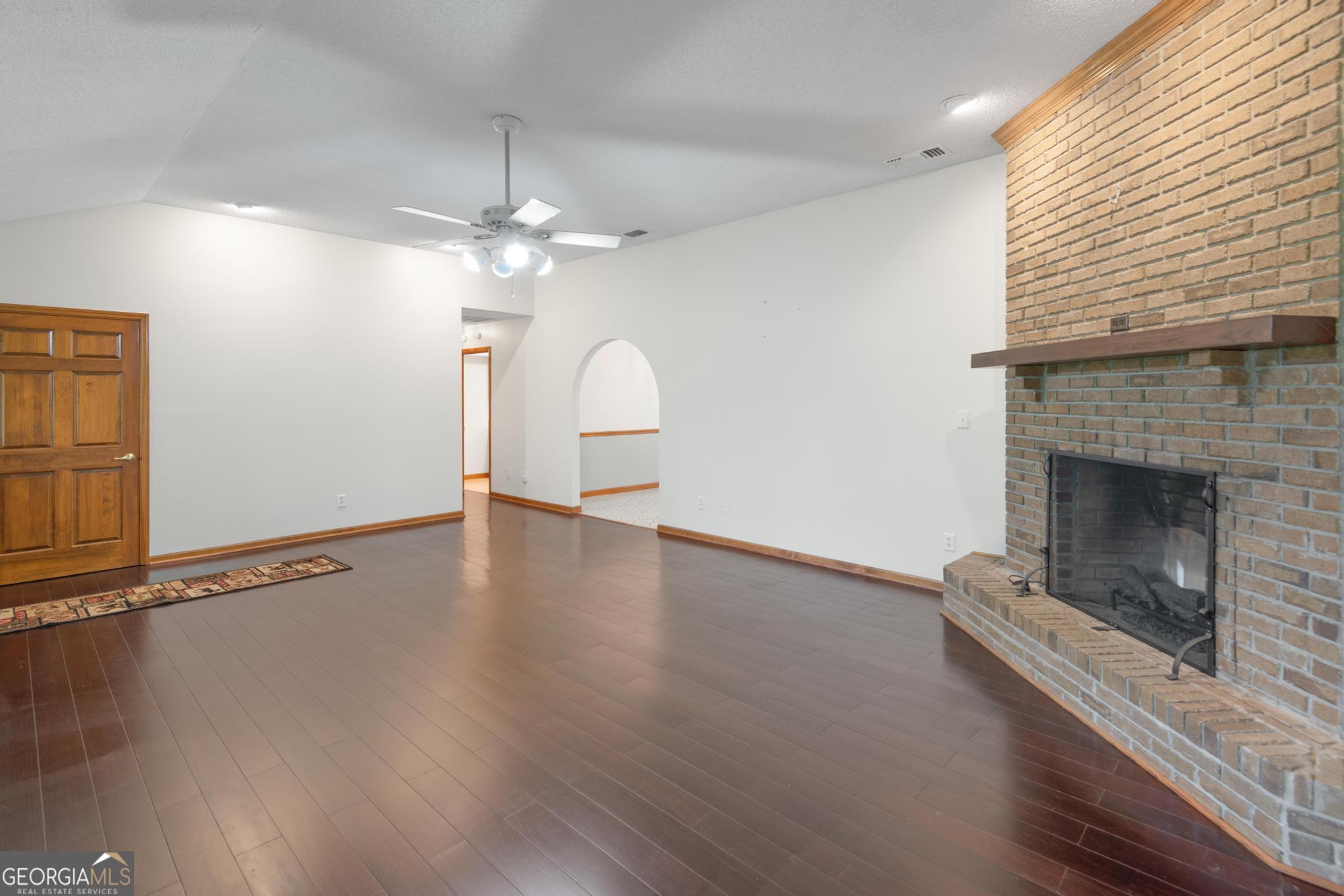 4909 Perry Road Claxton, GA 30417 - Photo 7 of 53 a view of empty room with wooden floor and fireplace