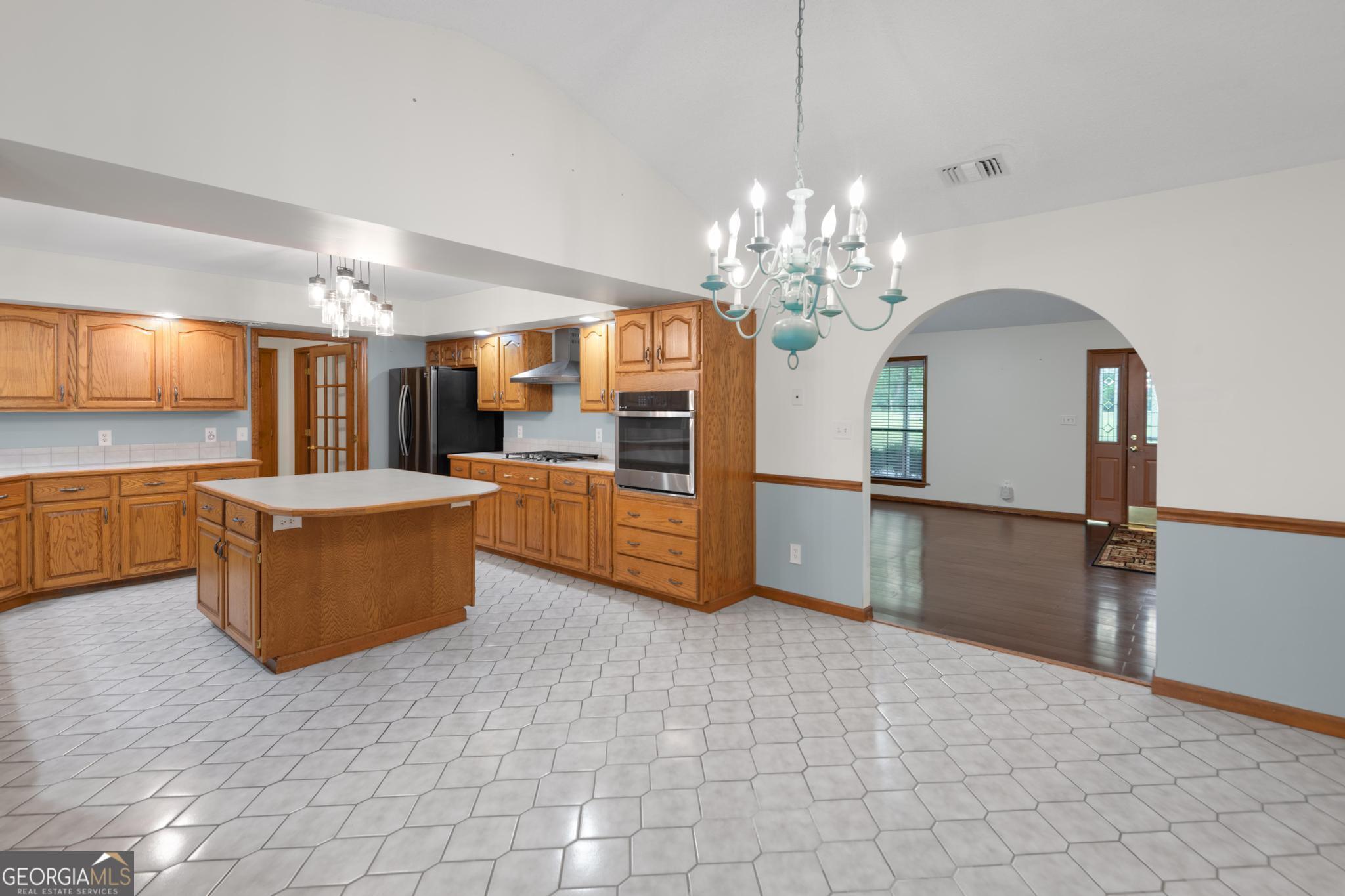 4909 Perry Road Claxton, GA 30417 - Photo 9 of 53 a view of a kitchen with kitchen island granite countertop a refrigerator and a stove top oven