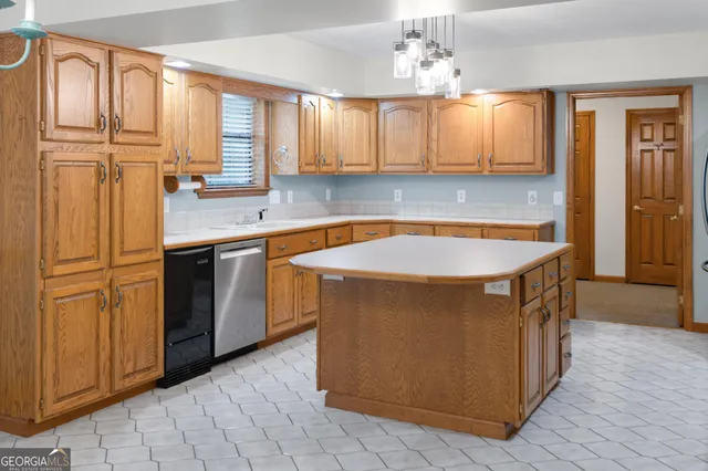 a utility room with stainless steel appliances granite countertop a sink a stove and a refrigerator