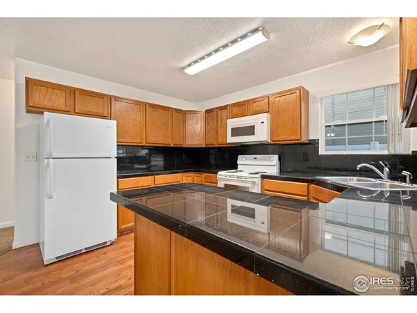 a kitchen with stainless steel appliances granite countertop a sink and a refrigerator