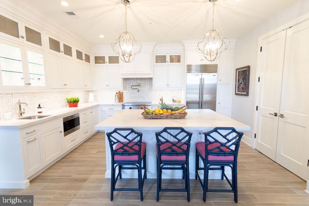 a dining room with stainless steel appliances a table chairs and chandelier