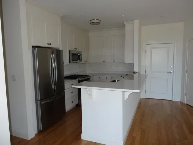 a kitchen with a refrigerator sink and cabinets