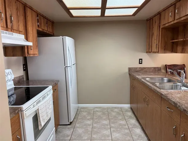 a kitchen with a sink a refrigerator and cabinets
