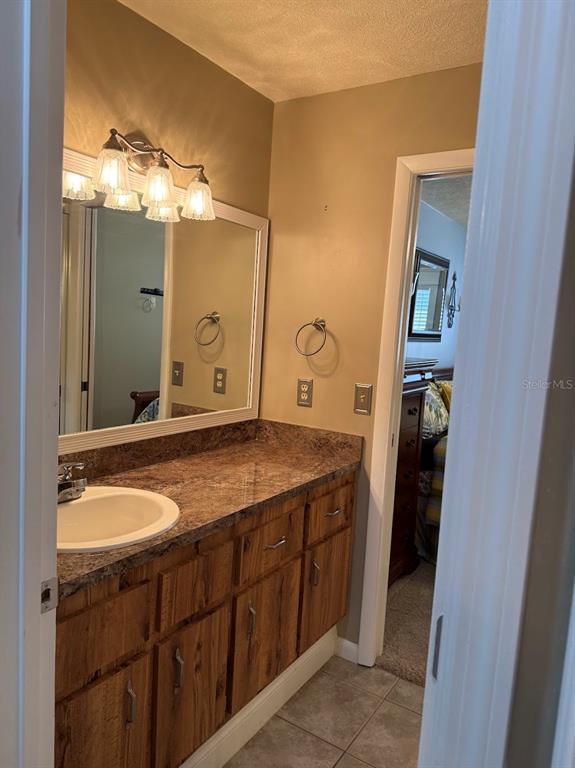 3021 Southeast 5th Terrace, Unit A Ocala, FL 34471 - Photo 8 of 13 a bathroom with a granite countertop sink and a mirror