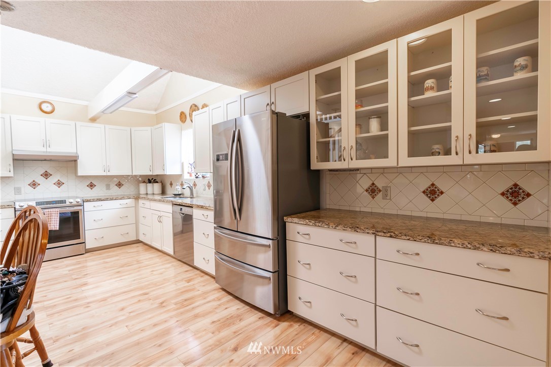 6502 Avondale Road Southwest, Unit 4 Lakewood, WA 98499 - Photo 12 of 28 a kitchen with stainless steel appliances granite countertop a refrigerator sink and cabinets