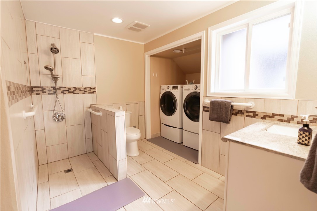 6502 Avondale Road Southwest, Unit 4 Lakewood, WA 98499 - Photo 17 of 28 a bathroom with a sink a mirror and a shower