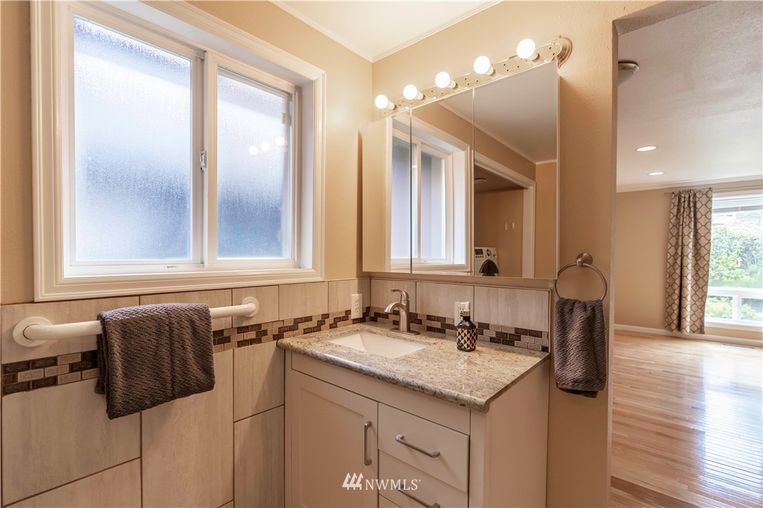 6502 Avondale Road Southwest, Unit 4 Lakewood, WA 98499 - Photo 18 of 28 a bathroom with a granite countertop sink and a mirror