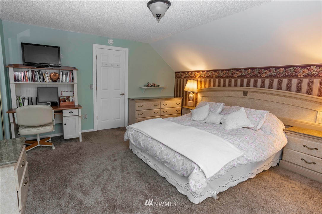 6502 Avondale Road Southwest, Unit 4 Lakewood, WA 98499 - Photo 25 of 28 a bedroom with a bed and a chair