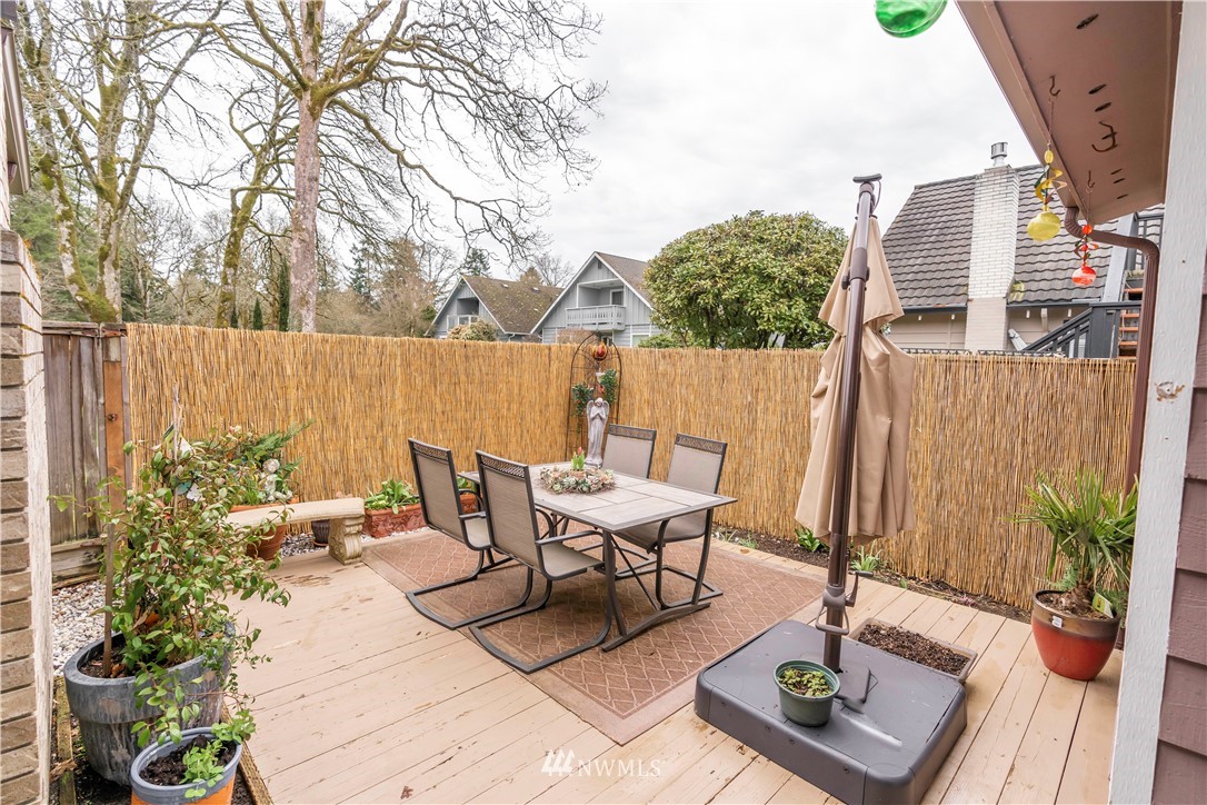 6502 Avondale Road Southwest, Unit 4 Lakewood, WA 98499 - Photo 9 of 28 a view of a patio with table and chairs potted plants and wooden fence