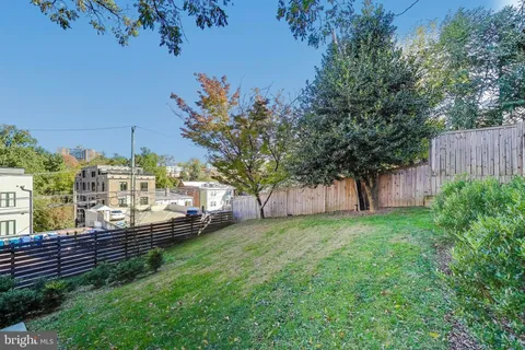 a view of a garden with a house in the background