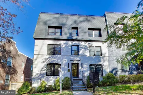 a front view of a house with plants