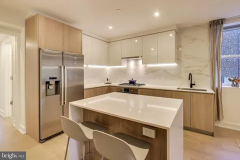 a kitchen with kitchen island a sink stove and refrigerator