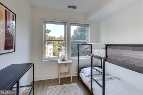 a bedroom with a bunk bed and a window