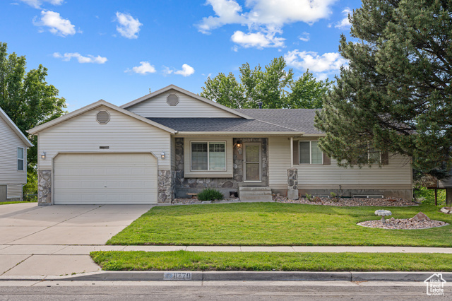 11770 East Dry Creek Road Sandy, UT 84094 - Photo 1 of 1 View of front of home featuring a garage, concrete driveway, a front yard, roof with shingles, and stone siding