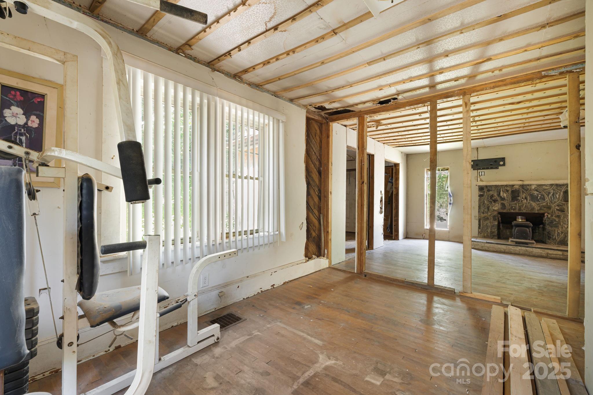 1277 Henson Cove Road Canton, NC 28716 - Photo 11 of 21 a view of an empty room with a fireplace and windows