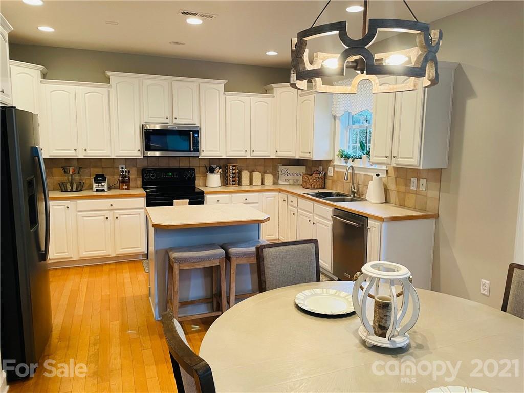6008 Colton Ridge Drive Indian Trail, NC 28079 - Photo 11 of 14 a kitchen with a sink a stove and chairs