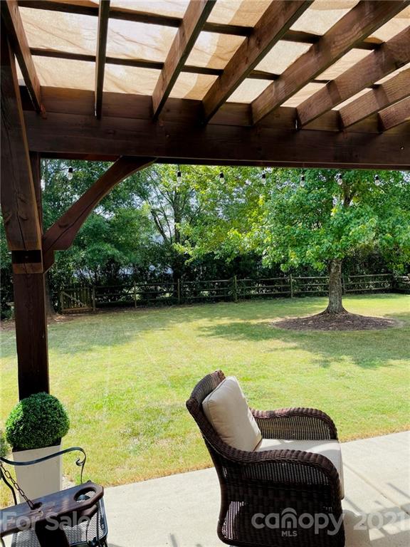 6008 Colton Ridge Drive Indian Trail, NC 28079 - Photo 4 of 14 a swimming pool with lawn chairs under an umbrella