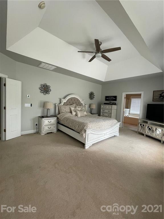 6008 Colton Ridge Drive Indian Trail, NC 28079 - Photo 7 of 14 a spacious bedroom with a bed and a ceiling fan