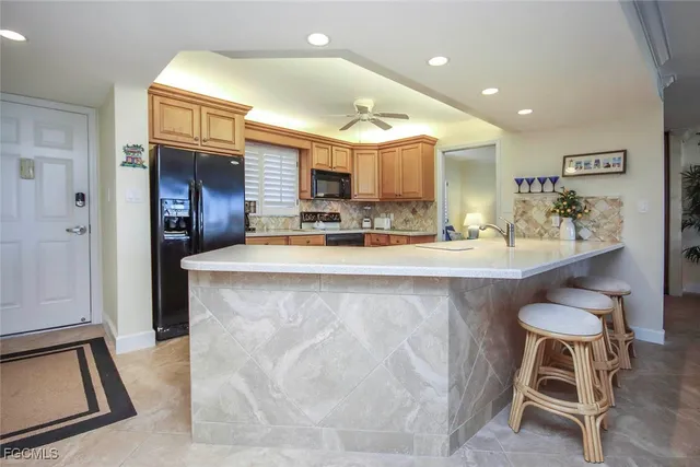 a kitchen with kitchen island granite countertop wooden cabinets and counter space