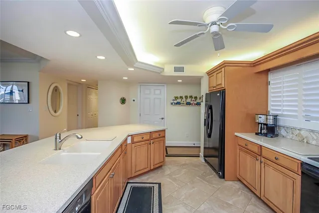 a large kitchen with a lot of counter space a sink and stainless steel appliances