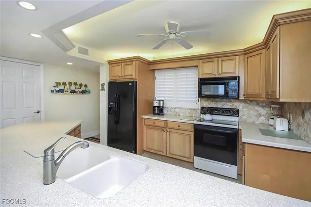 a kitchen with a sink appliances and cabinets