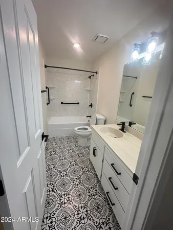 a bathroom with a sink a toilet a mirror and shower