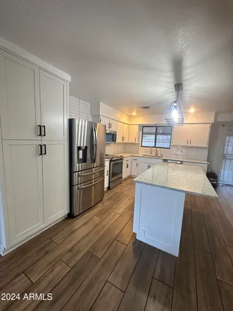 a kitchen with stainless steel appliances wooden floors and wooden cabinets