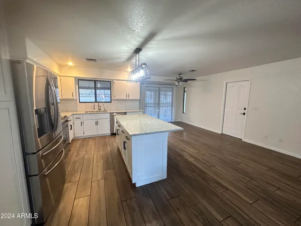 a kitchen with wooden floors and refrigerator
