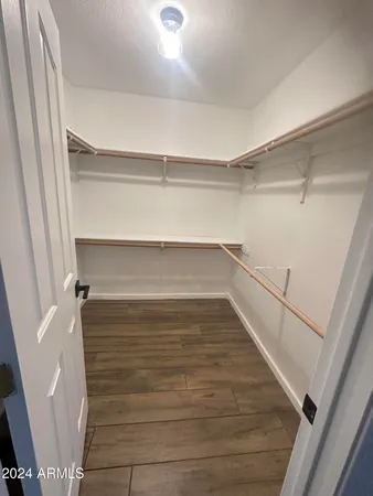 a view of walk in closet with empty racks