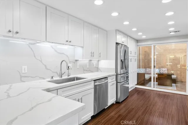 a kitchen with kitchen island a sink appliances and cabinets