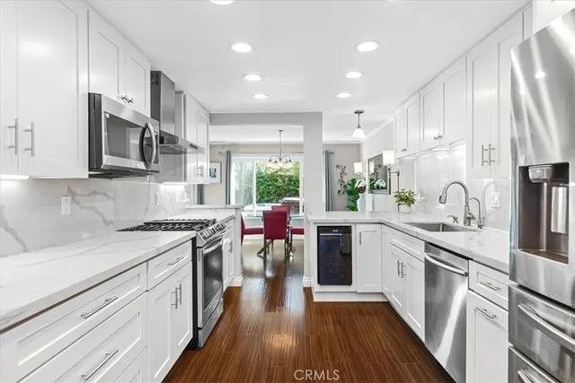 a kitchen with stainless steel appliances granite countertop sink stove top oven and cabinets