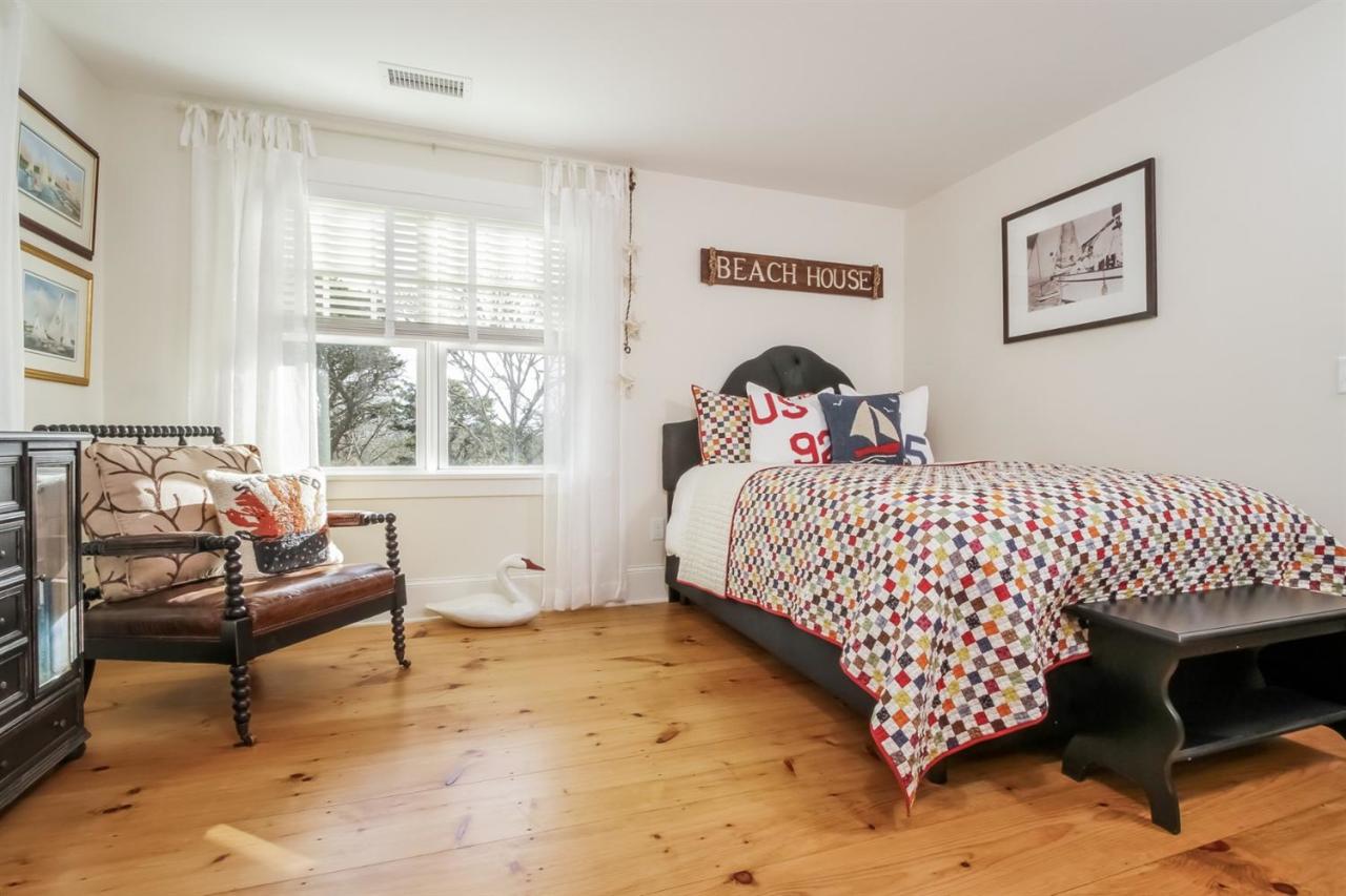 56 Sears Road Chatham, MA 02633 - Photo 11 of 14 a bedroom with a bed and wooden floor