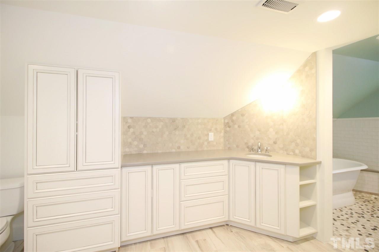 407 Polk Street Raleigh, NC 27604 - Photo 20 of 25 a view of a kitchen with white cabinets and wooden floor