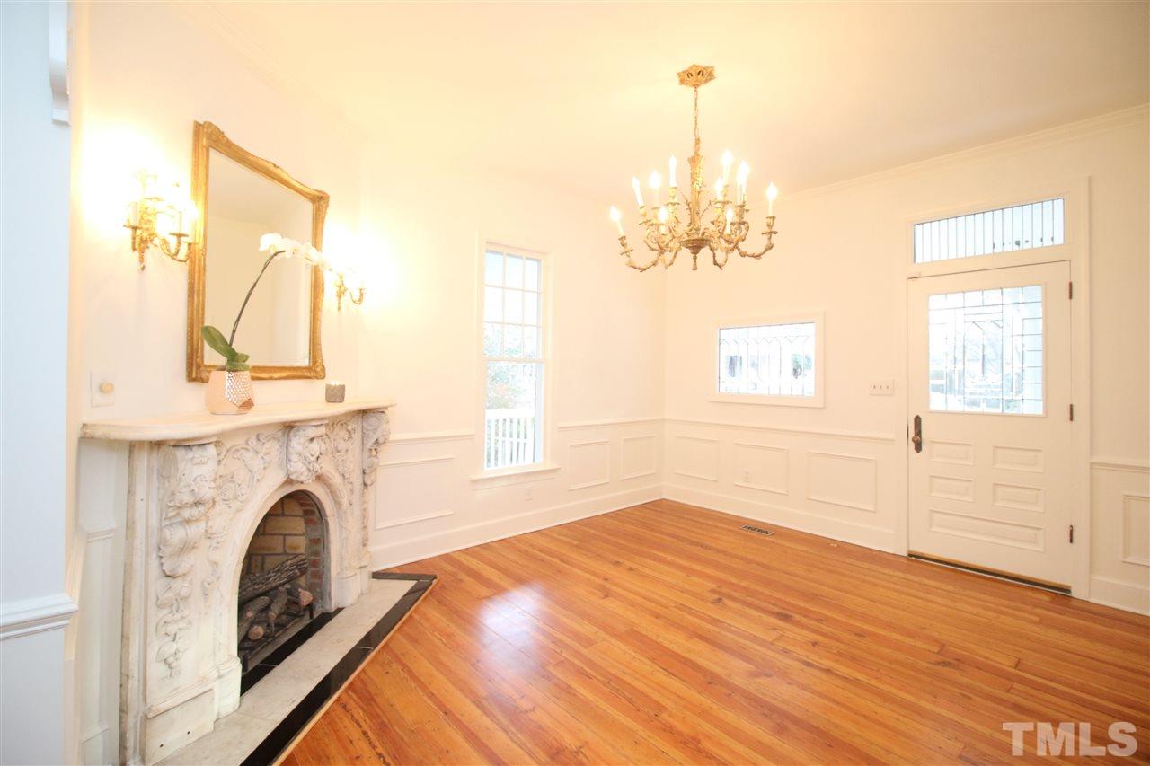 407 Polk Street Raleigh, NC 27604 - Photo 4 of 25 a view of a livingroom with a fireplace a chandelier and wooden floor