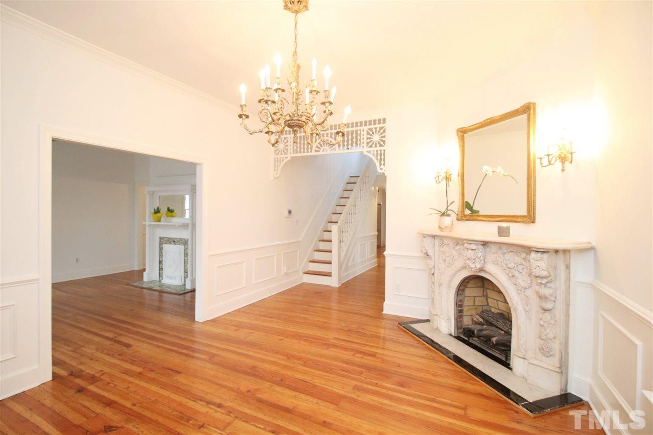 407 Polk Street Raleigh, NC 27604 - Photo 5 of 25 a view of a livingroom with a fireplace a chandelier and wooden floor