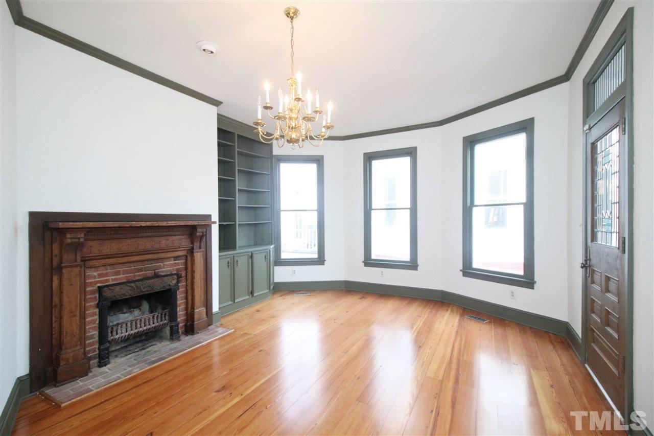 407 Polk Street Raleigh, NC 27604 - Photo 8 of 25 a view of an empty room with wooden floor fireplace and a window