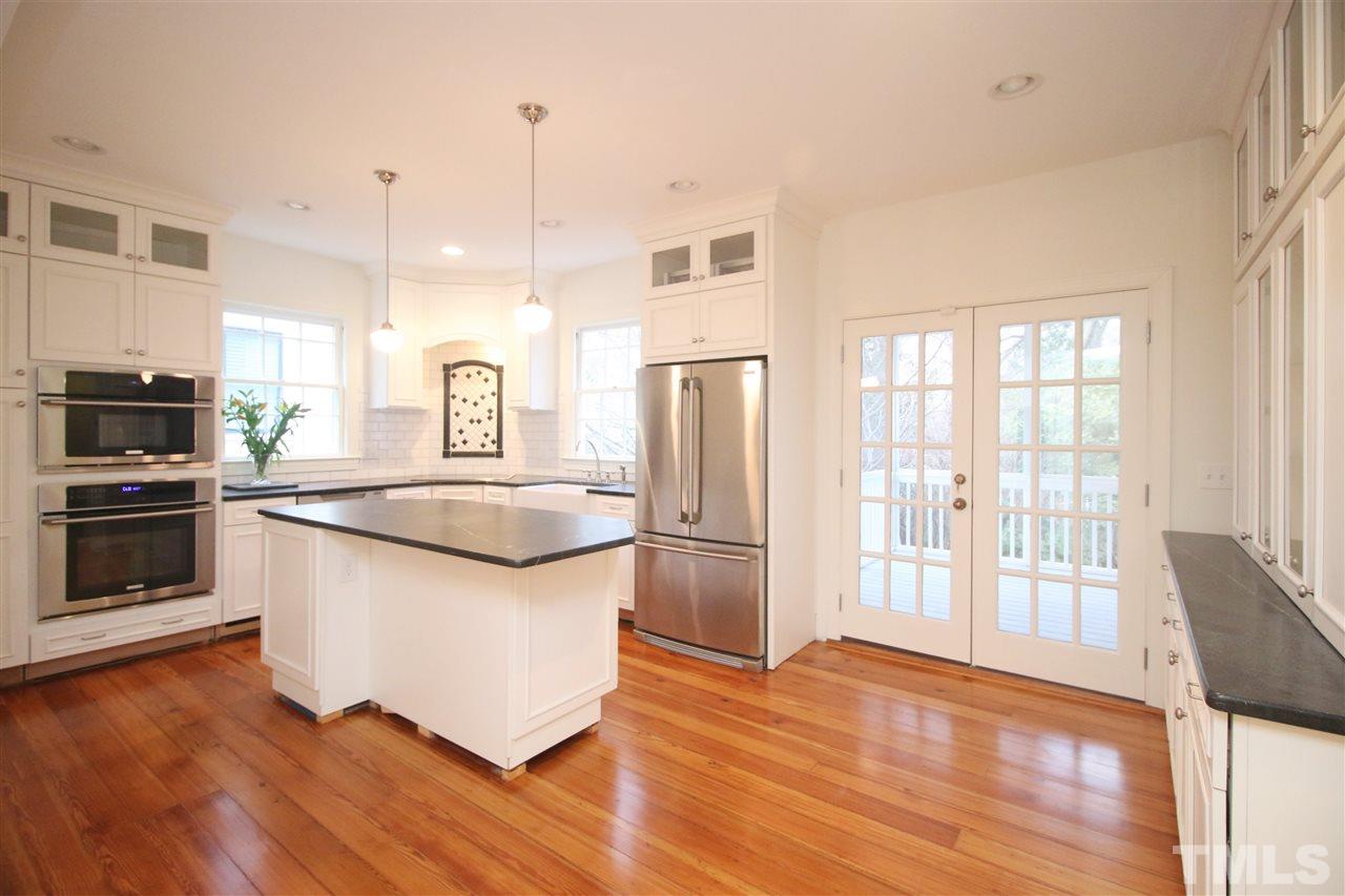 407 Polk Street Raleigh, NC 27604 - Photo 9 of 25 a kitchen with stainless steel appliances granite countertop a refrigerator a stove a sink and a large window