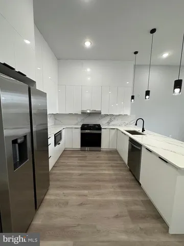 a view of kitchen with kitchen island and stainless steel appliances