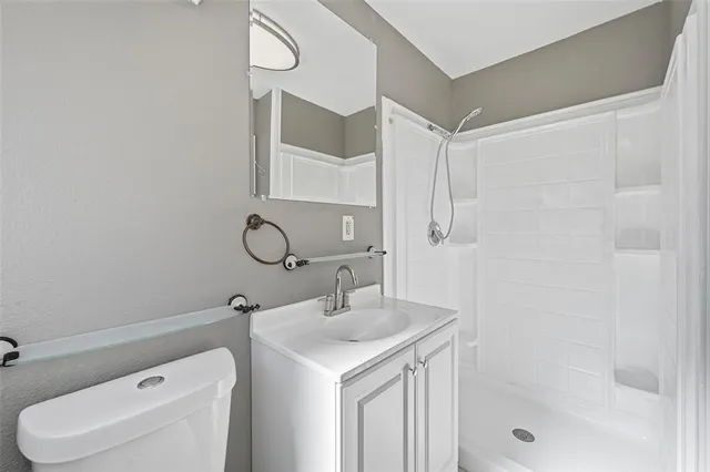 a bathroom with a sink toilet vanity and shower