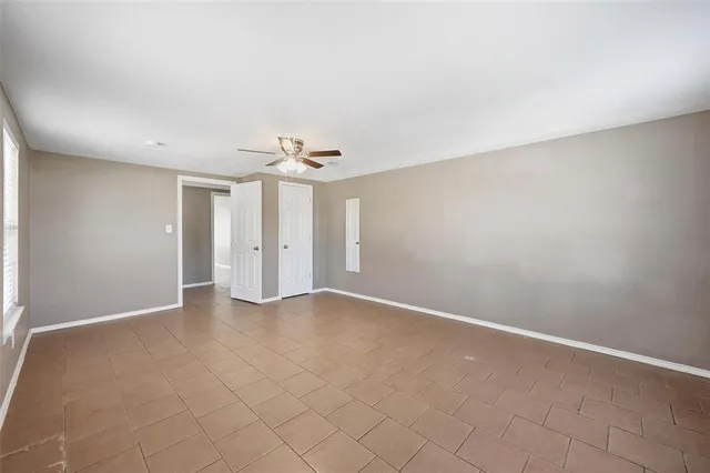 an empty room with chandelier fan