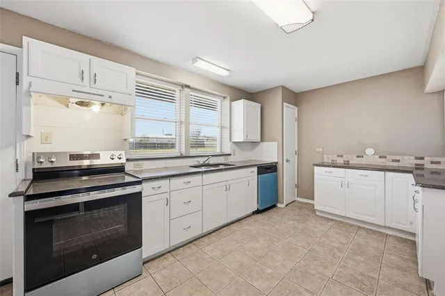 a kitchen with granite countertop white cabinets and white appliances