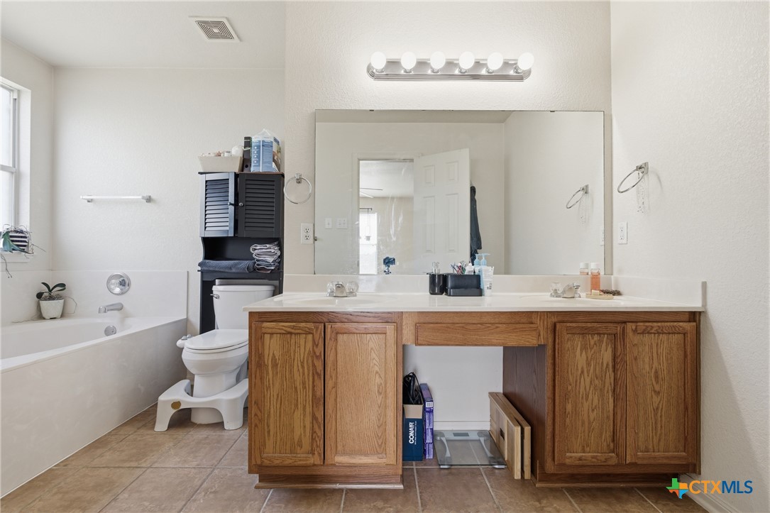 3310 Bull Run Drive Killeen, TX 76549 - Photo 13 of 27 a spacious bathroom with a double vanity sink a mirror and a toilet