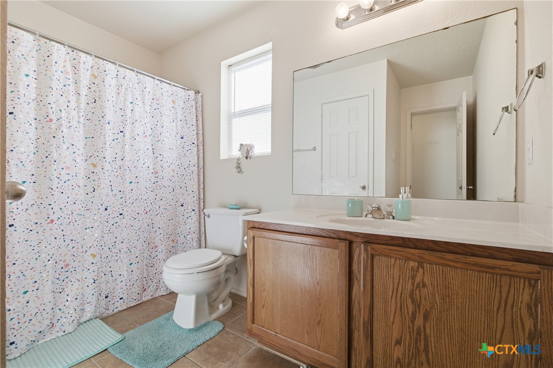 3310 Bull Run Drive Killeen, TX 76549 - Photo 23 of 27 a bathroom with a granite countertop sink a toilet and a mirror