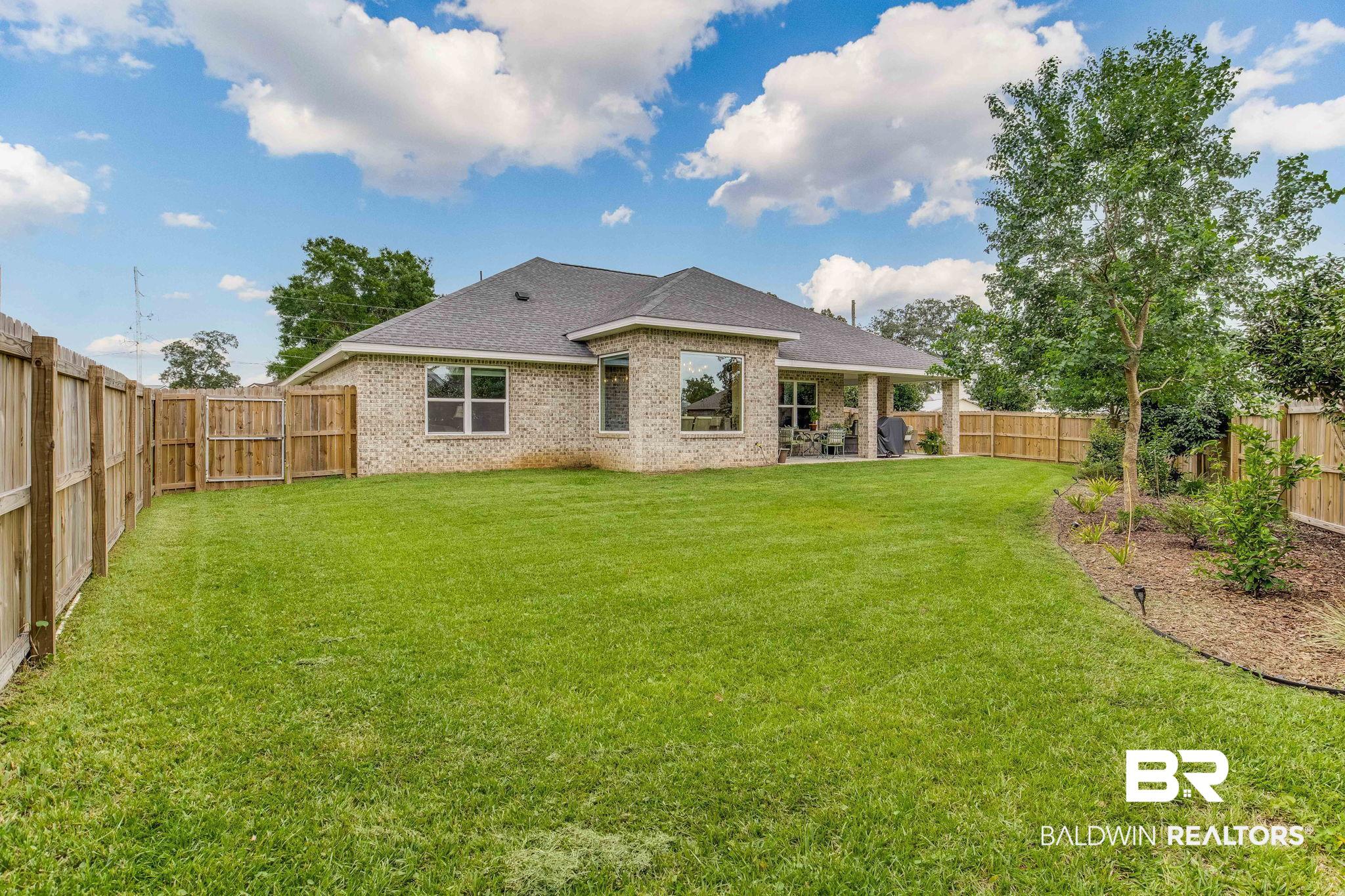 2222 Club House Drive Lillian, AL 36549 - Photo 29 of 49 Rear view of house with a fenced backyard, a patio, brick siding, and a shingled roof